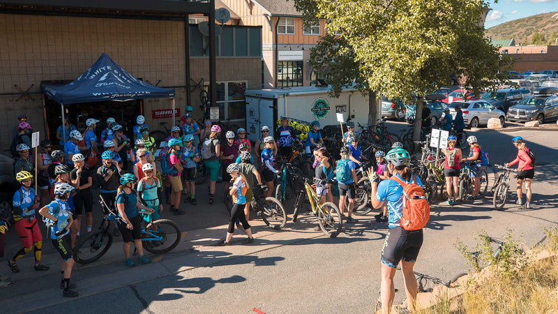Group of cyclists with bikes gathered outside a building