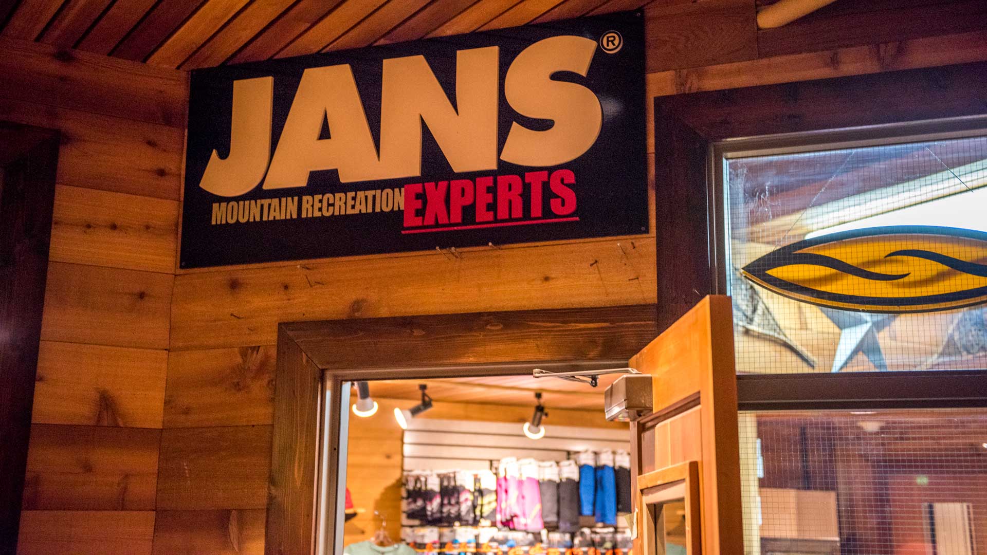Jans Mountain Recreation Experts sign on a wooden wall with a store interior visible.