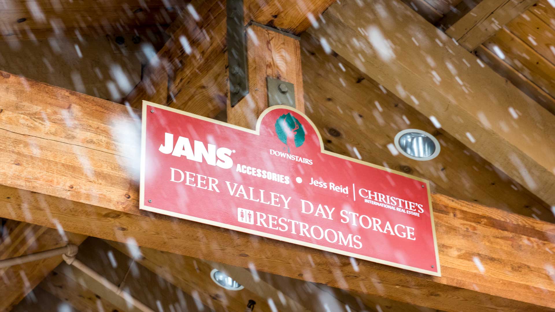 Red sign on wooden beams with snow falling