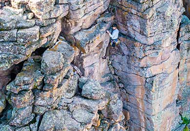 Person climbing a rocky cliff face