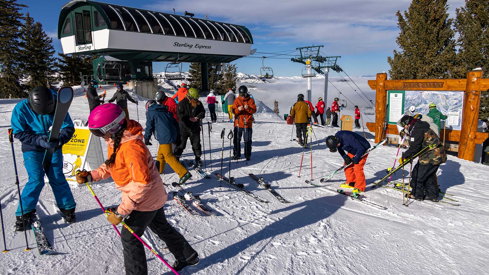 People skiing and snowboarding at a ski resort with a chairlift in the background.