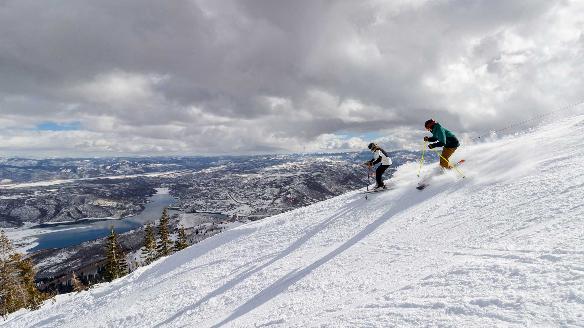 Jans Experts skiing on a groomed run overlooking a lake at Deer Valley Resort, Utah.