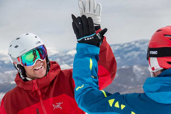 Jans Experts exchanging a high-five while skiing at Deer Valley Resort, Park City, Utah.