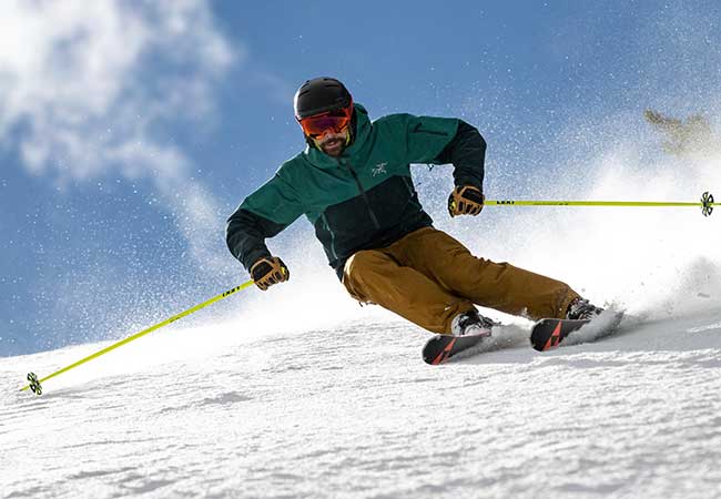 Skier in action on a snowy slope with a blue sky background