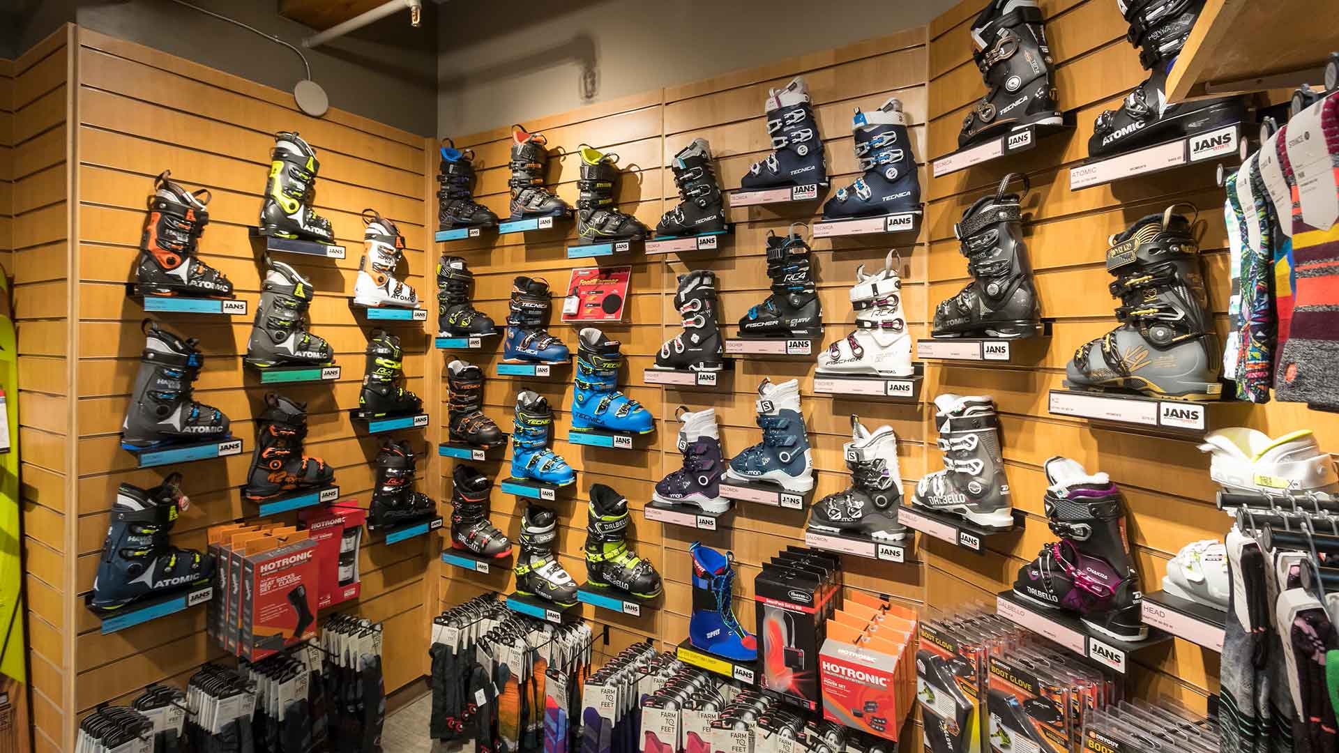 Alpine ski boots for sale on a display wall at Jans in Park City, Utah.