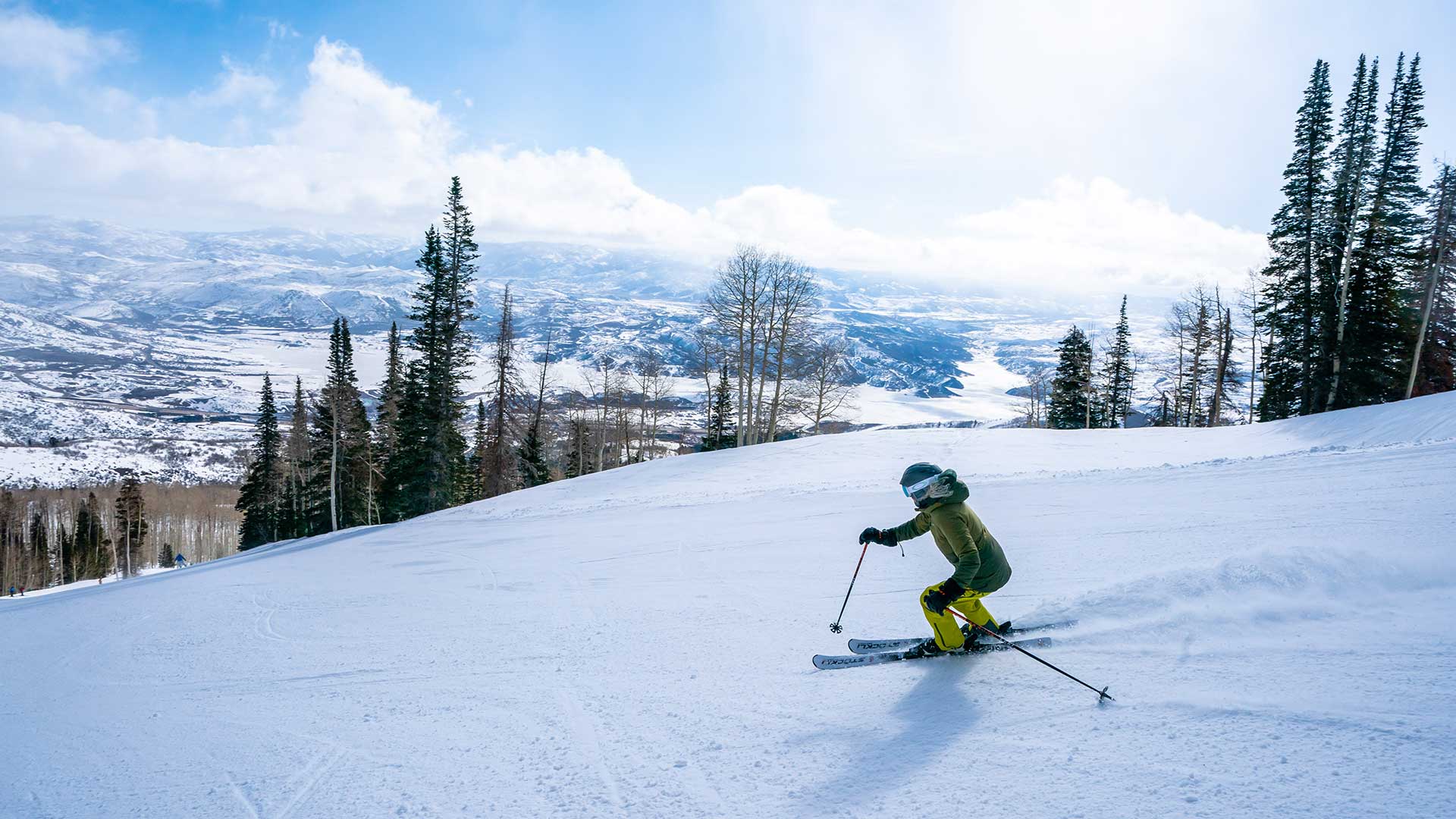 Jans Expert skiing on a groomed run overlooking a frozen lake in the background at Deer Valley Resort, Park City, Utah.