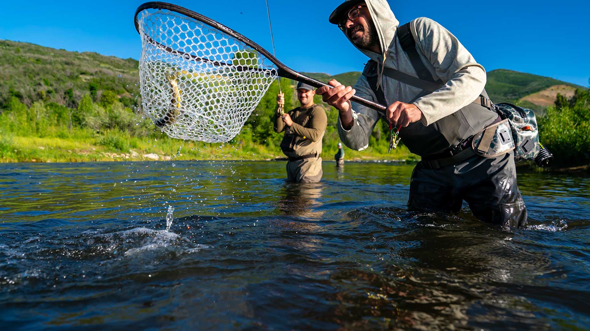 Jans Fly Fishing Guide netting a trout for a client on a guded fly fishing trip near Park City, Utah.
