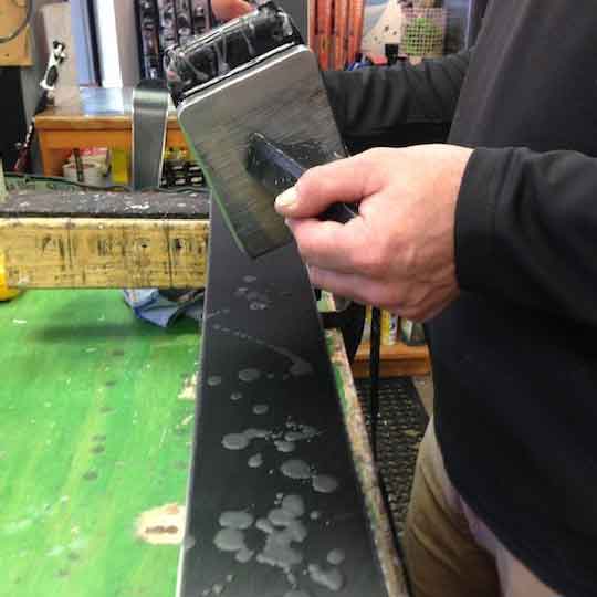 Jans Expert applying storage wax to skis.